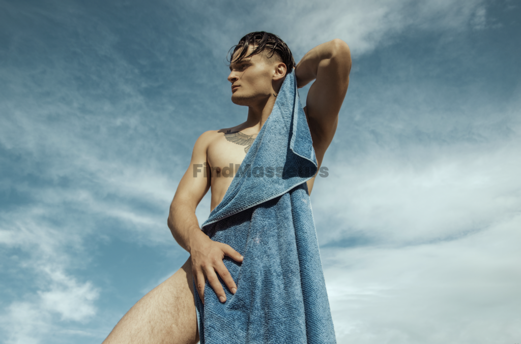 gay massage A young man with a wet hairstyle from a massage, holding a blue towel over his shoulder, standing under a blue sky with clouds. masseur